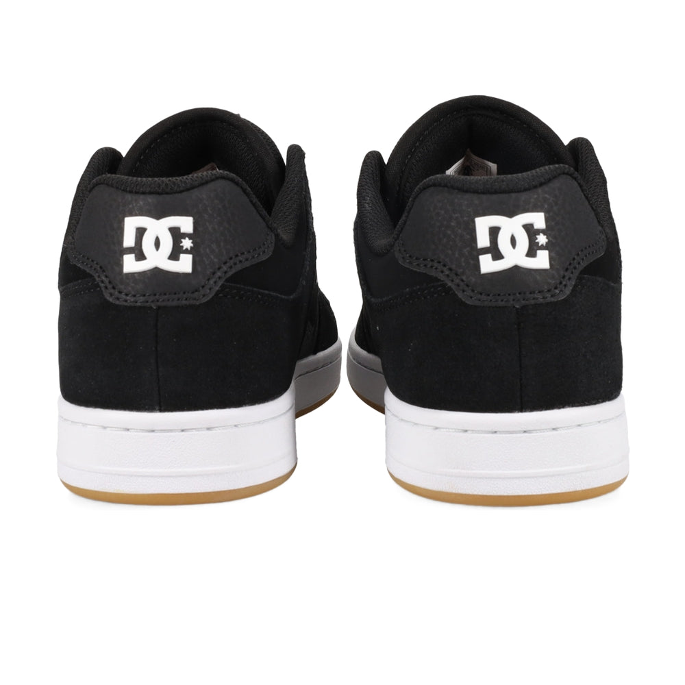 A rear view of a pair of black DC shoes with white soles.