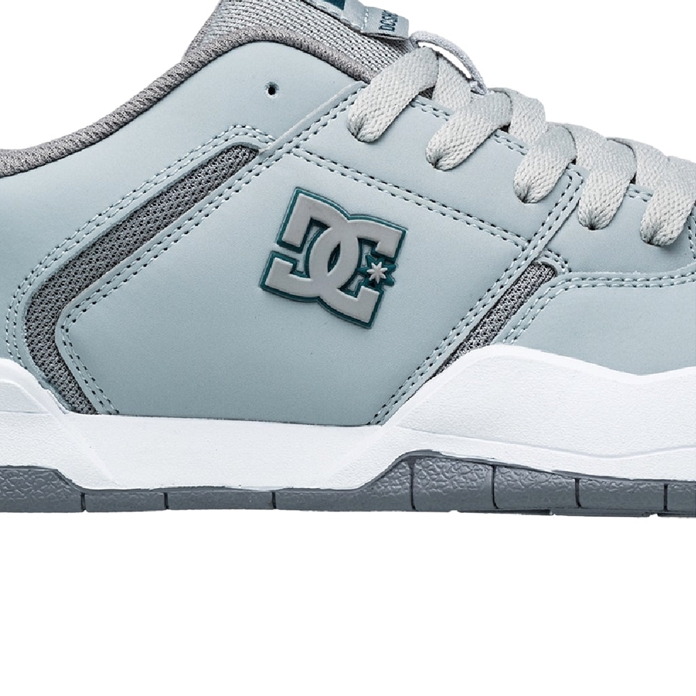 A close up of a bluish DC shoe with white and grey soles.