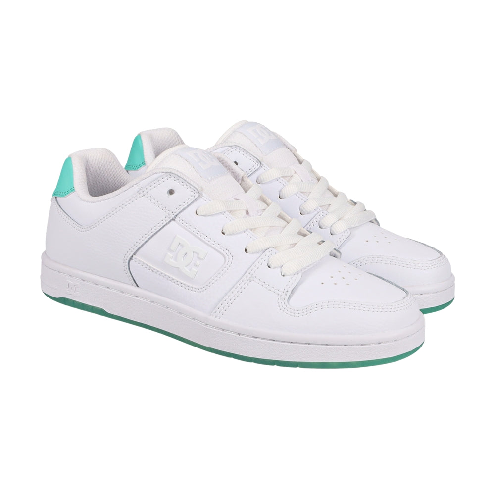 A pair of white DC shoes with green soles.