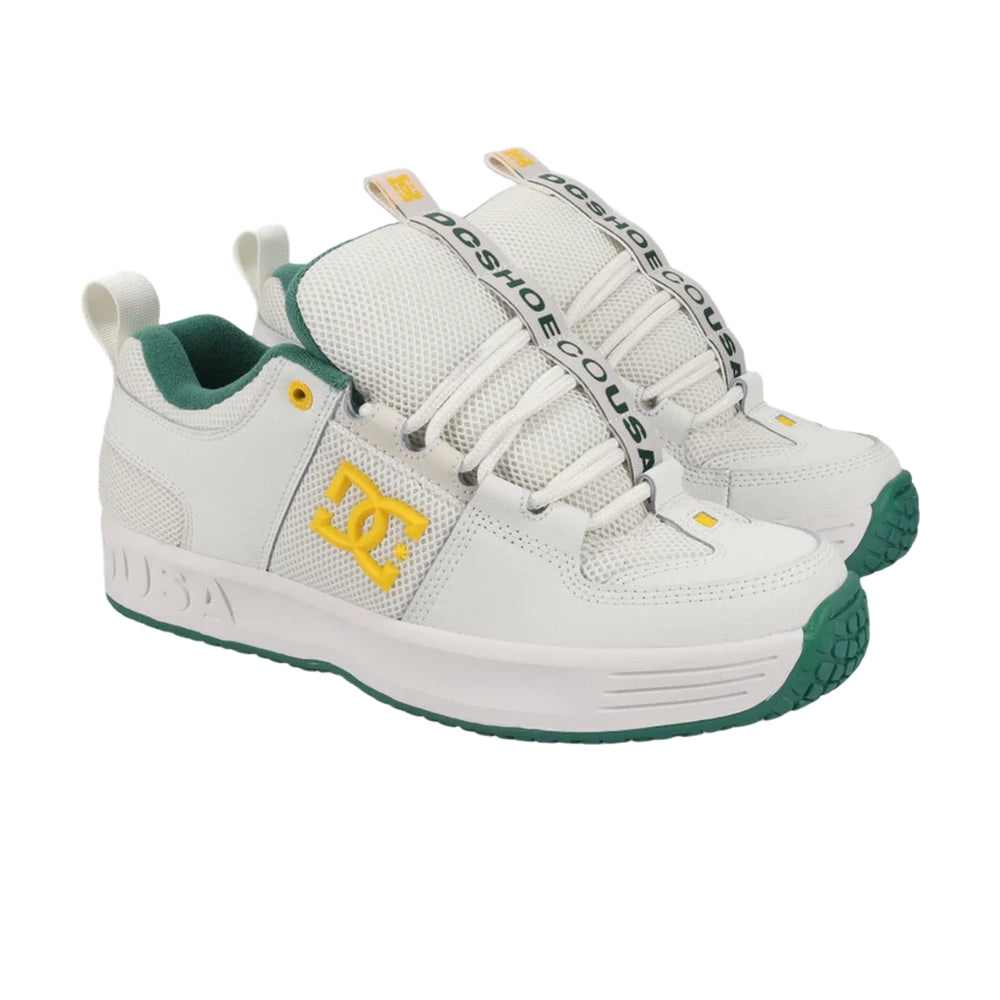 A pair of white DC shoes with green soles.