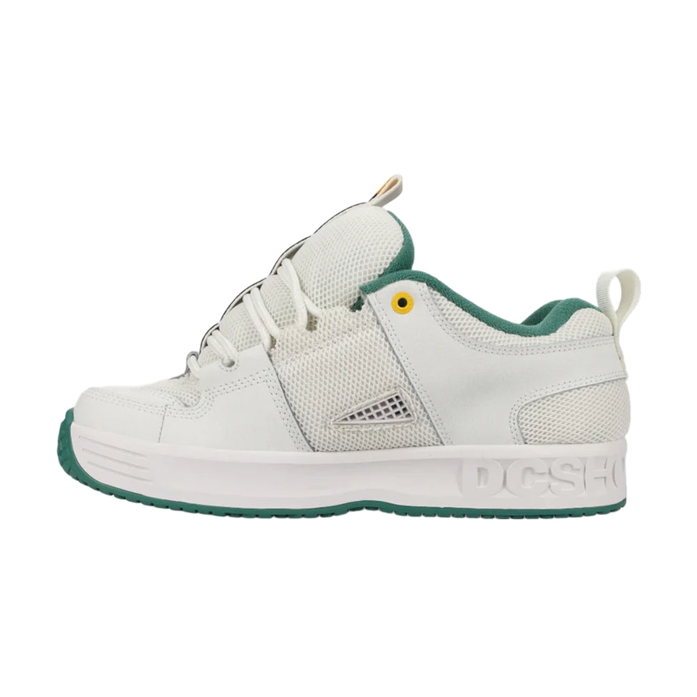 A white DC shoe with green soles.